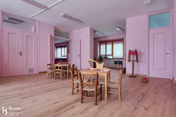 Sala con tavoli e sedie in legno